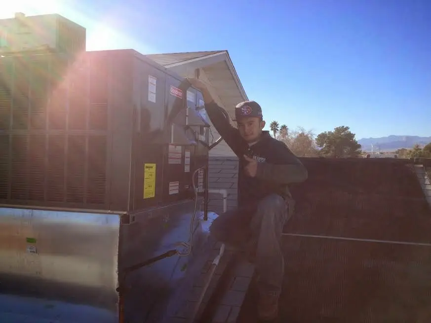 HVAC technician performing AC Tune-Up on a rooftop unit in River Forest